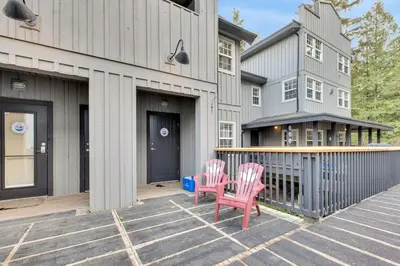 two pink chairs sitting on a patio in front of a house at Grey Whale, Pet Friendly Studio at The Beach in Ucluelet