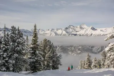 a group of people standing on top of a snow covered mountain at Moguls, Lofted Ski in Ski Out with Hot Tub Access in Panorama
