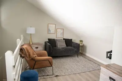 a living room with a couch and a chair at Moguls, Lofted Ski in Ski Out with Hot Tub Access in Panorama