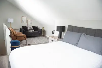 a bedroom with a bed and a couch and a chair at Moguls, Lofted Ski in Ski Out with Hot Tub Access in Panorama