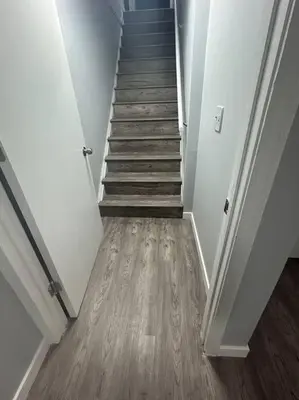 a hallway with a staircase with wooden floors and a stair case at Cute Highlandpark (Lower B Unit) in Calgary