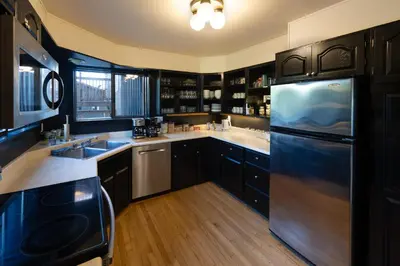 a kitchen with black cabinets and a stainless steel refrigerator at Boreale Ranch in Carcross