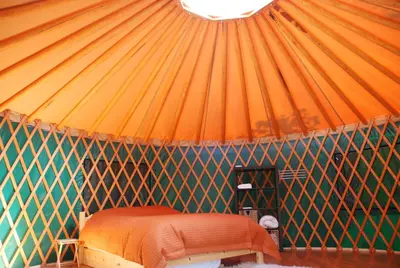 a room with an orange bed in a yurt at Boreale Ranch in Carcross