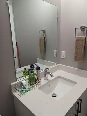 a bathroom counter with a sink and a mirror at Cozy Basement Suite - private entrance - Free Netflix in Edmonton