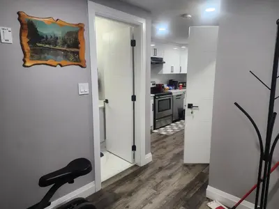 a kitchen with white walls and a treadmill in a room at Cozy Basement Suite - private entrance - Free Netflix in Edmonton