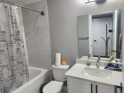 a bathroom with a toilet and a sink and a tub at Cozy Basement Suite - private entrance - Free Netflix in Edmonton