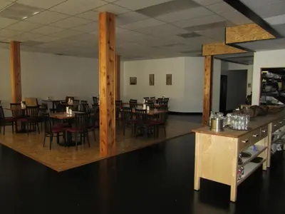 a dining room with wooden tables and chairs at The Mighty Fraser Motel in Boston Bar