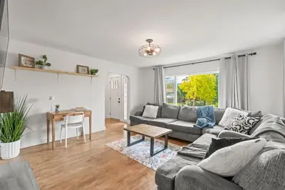 a living room with a couch and a table at Stunning Heritage Home, Sleep 8, Hot Tub, Private Yard, Firepit in Vernon