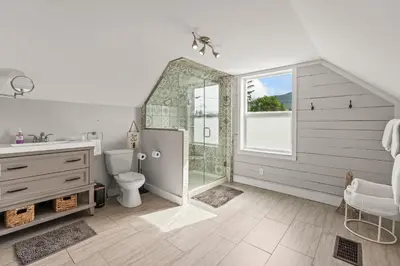 a bathroom with a shower and a toilet and a sink at Stunning Heritage Home, Sleep 8, Hot Tub, Private Yard, Firepit in Vernon