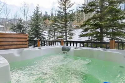 a jacuzzi tub filled with water in a yard at Thunder Ridge Chalet by Fernie Lodging Company in Fernie