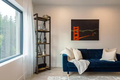 a living room with a blue couch and a window at Revelstoke Alpine Retreat - RARE One-Bedroom Condo in Revelstoke