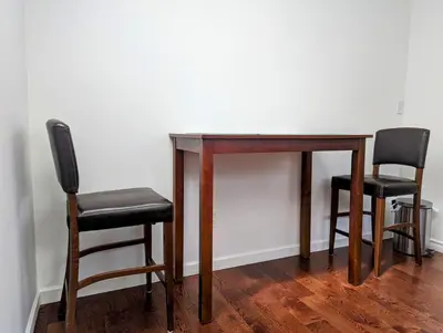 two chairs and a wooden table with two chairs at Ocean Park Loft in Surrey