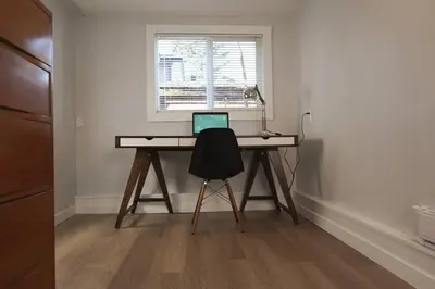 a desk with a laptop on it in a room at Private Suite Steps to Main St. in Vancouver