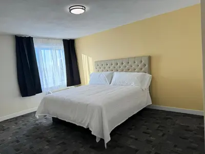 a bedroom with a bed with white sheets and a window at The Viking Inn in Viking