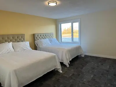 two beds in a room with a window at The Viking Inn in Viking
