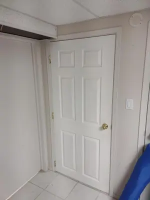 a white door in a room with a tile floor at A Place to Call Home in Edmonton