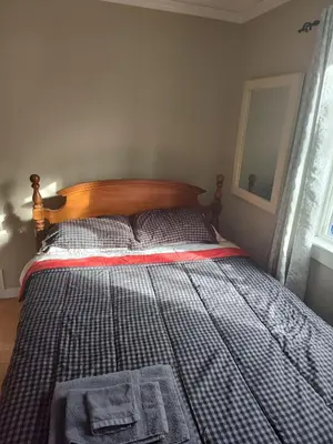 a bed in a bedroom with a blanket on it at A Place to Call Home in Edmonton