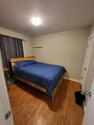 a bedroom with a bed with a blue comforter at A Place to Call Home in Edmonton