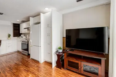 a living room with a large flat screen tv at Simplistic 2BR Suite near Nose Hill & Airport in Calgary