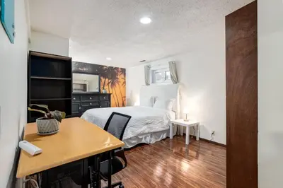 a small bedroom with a bed and a desk at Simplistic 2BR Suite near Nose Hill & Airport in Calgary