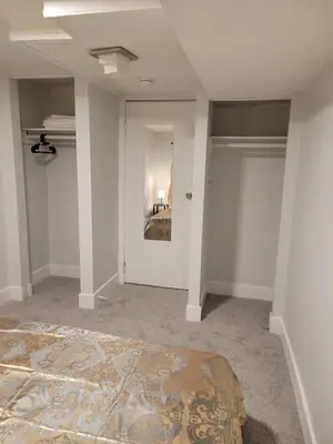 an empty room with a bed and a mirror at Private Family Hideaway or Business Travel in Edmonton - 2 Bedroom Apartment in Edmonton