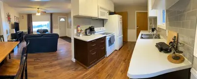 a large kitchen with white counters and a counter top at Mountain View Executive Suite in Grande Cache