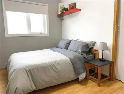 a bedroom with a bed and a window and a table at Mountain View Executive Suite in Grande Cache