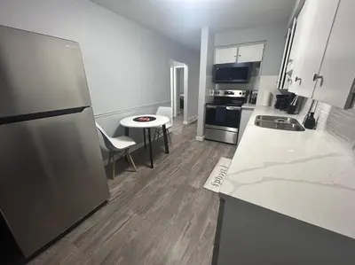 a kitchen with a refrigerator and a table in it at Cute Highland Park Entire Unit A in Calgary