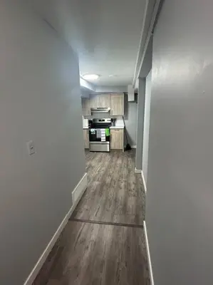 an empty room with a kitchen and a hallway at Cute Highland Park Entire Unit B in Calgary