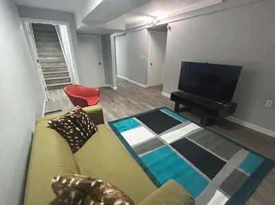 a living room with a couch and a flat screen tv at Cute Highland Park Entire Unit B in Calgary