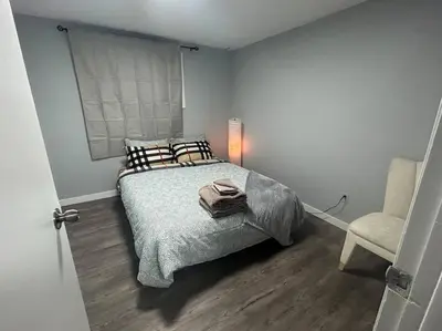 a bedroom with a bed and a chair at Cute Highland Park Entire Unit B in Calgary