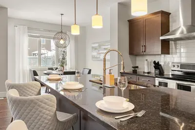 a kitchen with a large island with a table and chairs at Luxurious Entire House with Cental AC, Double Car Garage Parking, Upgraded Appliances, King Size Bed, Two Living Rooms & More in Nisku