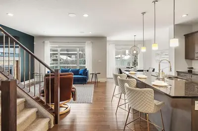 a kitchen and living room with a table and chairs at Luxurious Entire House with Cental AC, Double Car Garage Parking, Upgraded Appliances, King Size Bed, Two Living Rooms & More in Nisku