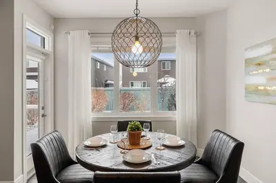 a dining room with a table and chairs and a chandelier at Luxurious Entire House with Cental AC, Double Car Garage Parking, Upgraded Appliances, King Size Bed, Two Living Rooms & More in Nisku