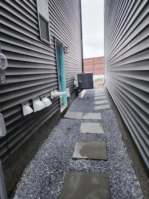 a walkway leading to a building with toilet paper dispensers at Trendy 2-Bed Oasis Awaits! in Calgary