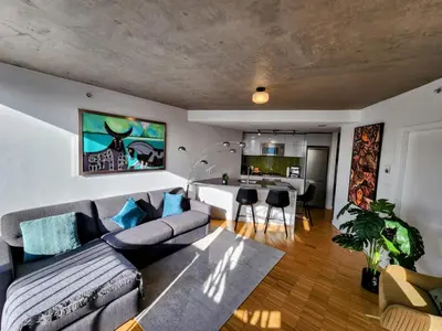 a living room with a couch and a dining room at Luxury Downtown Vancouver Suite in Vancouver