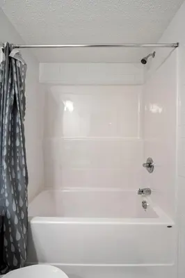 a white bathroom with a tub and a toilet at Angie’s place in Calgary