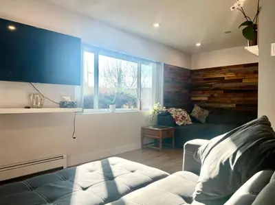 a living room with a couch and a large window at Westview Vacation Rental - Two BR House in North Vancouver