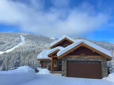 a house with a garage in the snow at Morrisey Chalet at Sun Peaks in Sun Peaks