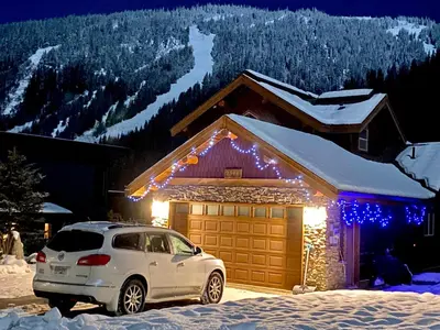 a car parked in front of a garage with christmas lights at Morrisey Chalet at Sun Peaks in Sun Peaks