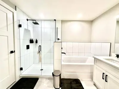 a white bathroom with a tub and a shower at Dreamy Panoramic Lakeview 1 Bedroom plus Den in Harrison Hot Springs
