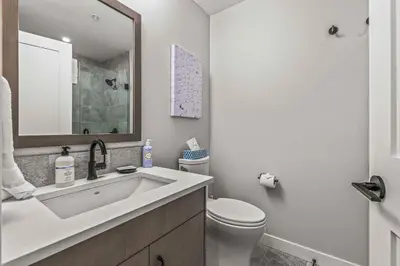 a white bathroom with a sink and a toilet at Brand New - TimberLodge Spacious 2br in Canmore