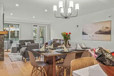 a dining room and living room with a table and chairs at Brand New - TimberLodge Spacious 2br in Canmore