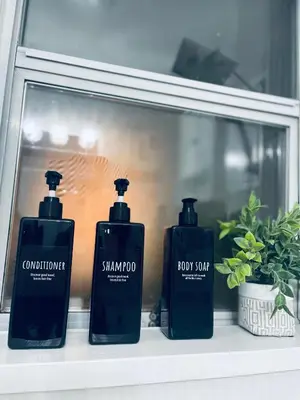 three bottles of shampoo and soap sitting on a shelf at La Maison in Vancouver
