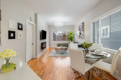 a dining room and living room with a table and chairs at La Maison in Vancouver