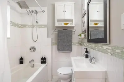 a white bathroom with a sink and a tub and a toilet at La Maison in Vancouver