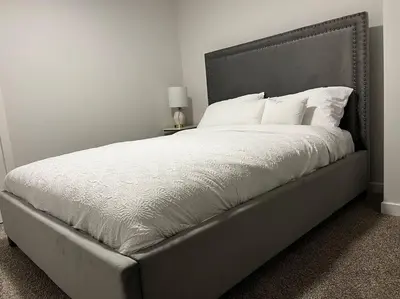 a bedroom with a large bed with white sheets and pillows at Brand New - Home Away from Home in NW Calgary in Calgary