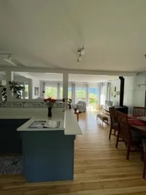 a kitchen and living room with a table and chairs at Sweet Creek Retreat in Nelson