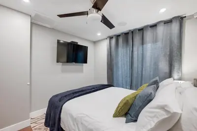 a bedroom with a bed and a flat screen tv at Vi Cottage in North Saanich