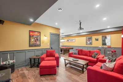 a waiting room with red couches and a pool table at Vi Cottage in North Saanich